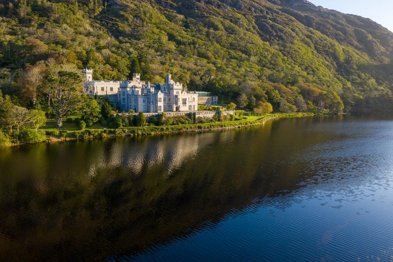 Kylemore Abbey reflected in a lake surrounded by the mountains of Connemara